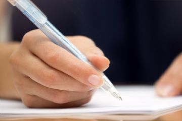 mano che compila a penna documenti